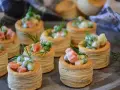 Petits bouchées à la reine, garnies d'une salade crémeuse de petits pois, carottes et jambon, décorées d'aneth. Parfaites pour un apéritif gourmand.