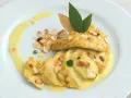 Délicieux poulet au curry, garni d'amandes effilées et d'une sauce onctueuse, servi sur une assiette blanche.