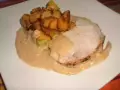 Tranche de roti de porc au lait, nappée d'une sauce onctueuse, accompagnée de pommes de terre rôties croustillantes. Un plat réconfortant.