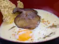 Un œuf parfait, crémeux et onctueux, baigne dans une soupe onctueuse, garnie d'un champignon poêlé et d'une tuile croustillante.