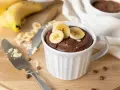 Un délicieux mug cake banane au chocolat, garni de rondelles de banane fraîche. Parfait pour une envie gourmande rapide.