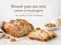 Un pain aux noix artisanal, tranché, avec une mie aérée et une croûte dorée. Des noix parsèment la mie et quelques-unes sont disposées autour.