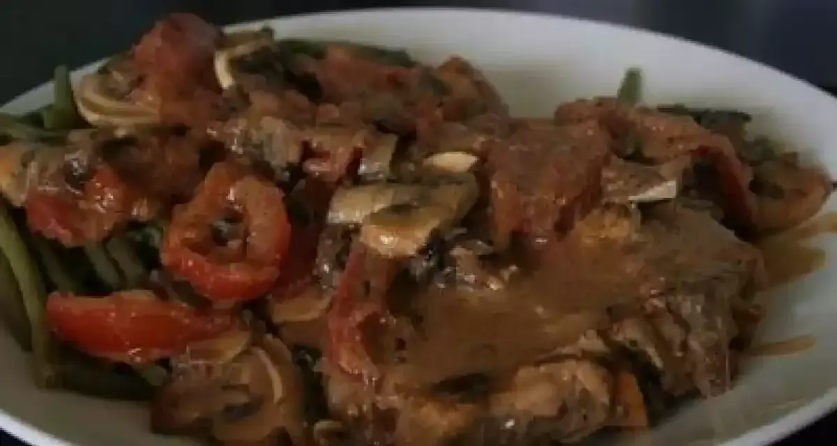 Un savoureux sauté de veau tomates champignons, servi avec des haricots verts. Un plat réconfortant et plein de saveurs.