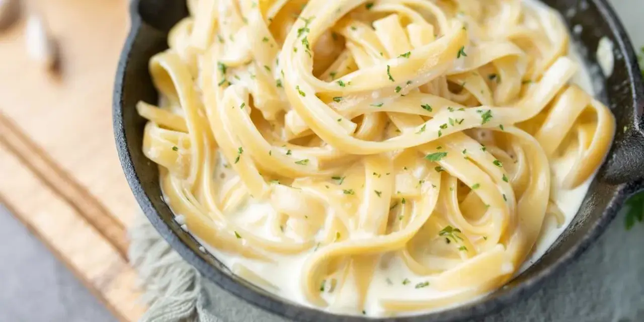 Fettuccine crémeux enrobé d'une onctueuse sauce fromage blanc, parsemé de persil frais. Un délice réconfortant.