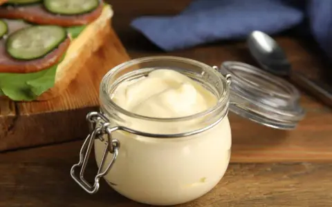 Un pot de mayonnaise maison sans oeuf, crémeuse et onctueuse, prête à garnir un sandwich.