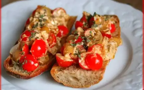 Deux délicieuses bruschettas au four garnies de tomates cerises et d'herbes fraîches, parfaites pour une recette facile.