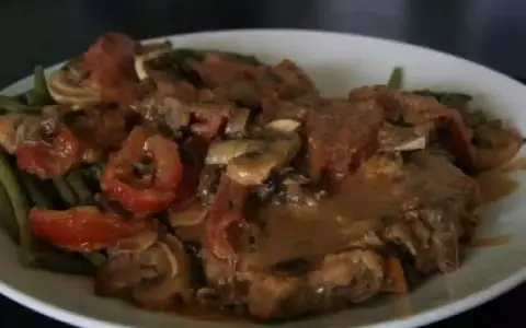 Un savoureux sauté de veau tomates champignons, servi avec des haricots verts. Un plat réconfortant et plein de saveurs.