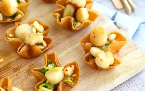 Bouchées à la reine aux Saint-Jacques, garnies d'une béchamel crémeuse et de pignons. Un délice croustillant.