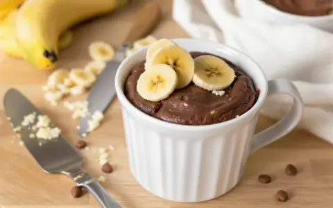 Un délicieux mug cake banane au chocolat, garni de rondelles de banane fraîche. Parfait pour une envie gourmande rapide.