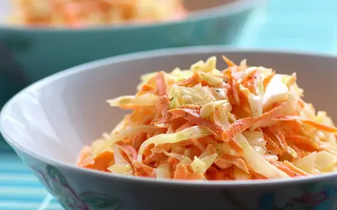 Un bol de véritable sauce coleslaw, mélange frais de chou râpé et de carottes, assaisonné de poivre noir.