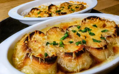 Deux gratins de soupe à l'oignon, dorés et gratinés, prêts à être dégustés. Une recette réconfortante.