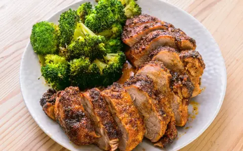 Filet mignon air fryer, tranché et servi avec du brocoli rôti. Un repas sain et savoureux.