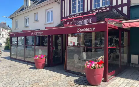 Brasserie Le Normandie, un lieu idéal pour déguster un bon pont l'évêque, fromage au goût unique. Fleurs colorées devant.