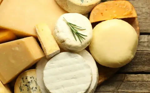 Assortiment de fromages variés, dont un bleu persillé, un camembert et un fromage rond crémeux, parfaits pour un plateau de **sucre de lait** gourmand.
