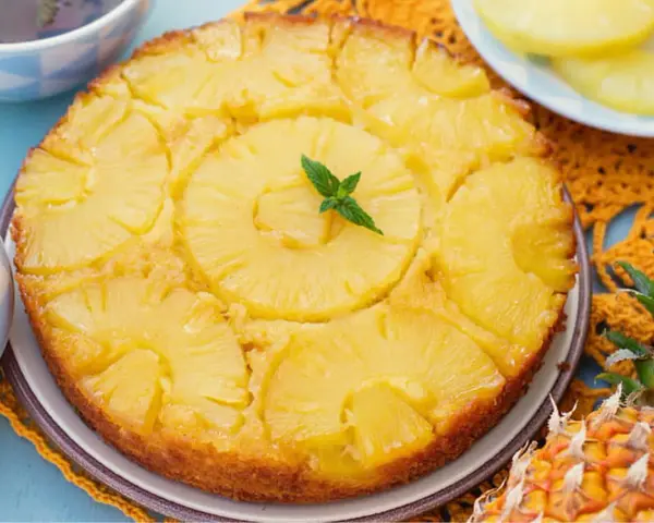 Gâteau renversé aux ananas, garni de menthe fraîche. Une délicieuse recette de gâteau ananas, parfaite pour le dessert.
