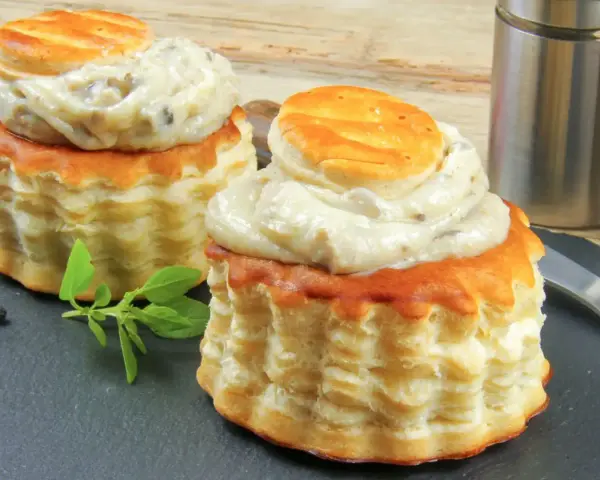 Deux bouchées à la reine garnies d'une sauce crémeuse aux champignons. La différence vol au vent et bouchée à la reine est subtile, mais ces délices sont irrésistibles.