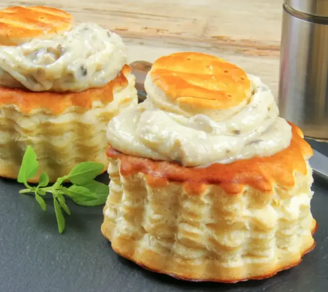 Deux bouchées à la reine garnies d'une sauce crémeuse aux champignons. La différence vol au vent et bouchée à la reine est subtile, mais ces délices sont irrésistibles.