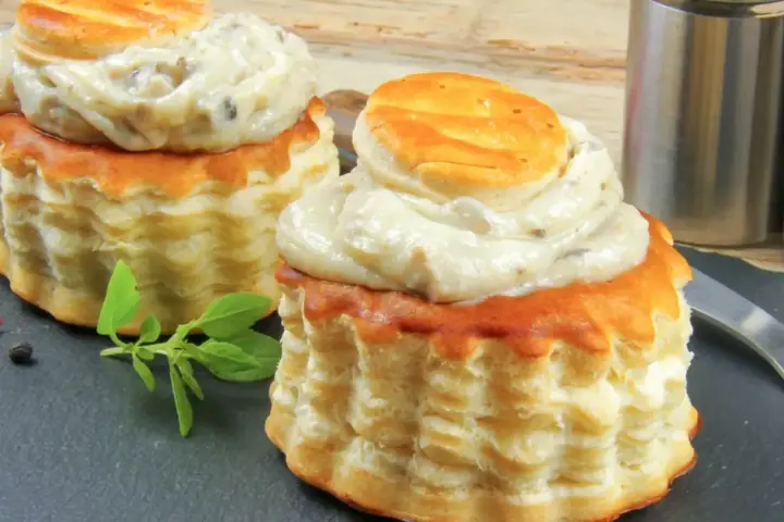 Deux bouchées à la reine garnies d'une sauce crémeuse aux champignons. La différence vol au vent et bouchée à la reine est subtile, mais ces délices sont irrésistibles.