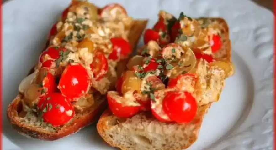 Deux délicieuses bruschettas au four garnies de tomates cerises et d'herbes fraîches, parfaites pour une recette facile.
