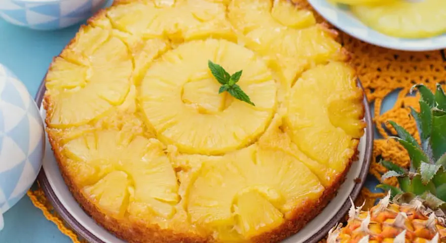 Gâteau renversé aux ananas, garni de menthe fraîche. Une délicieuse recette de gâteau ananas, parfaite pour le dessert.