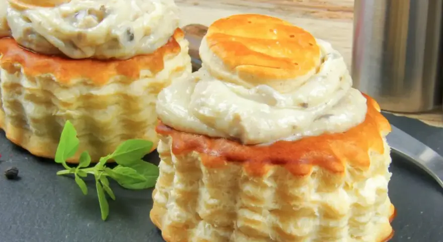 Deux bouchées à la reine garnies d'une sauce crémeuse aux champignons. La différence vol au vent et bouchée à la reine est subtile, mais ces délices sont irrésistibles.