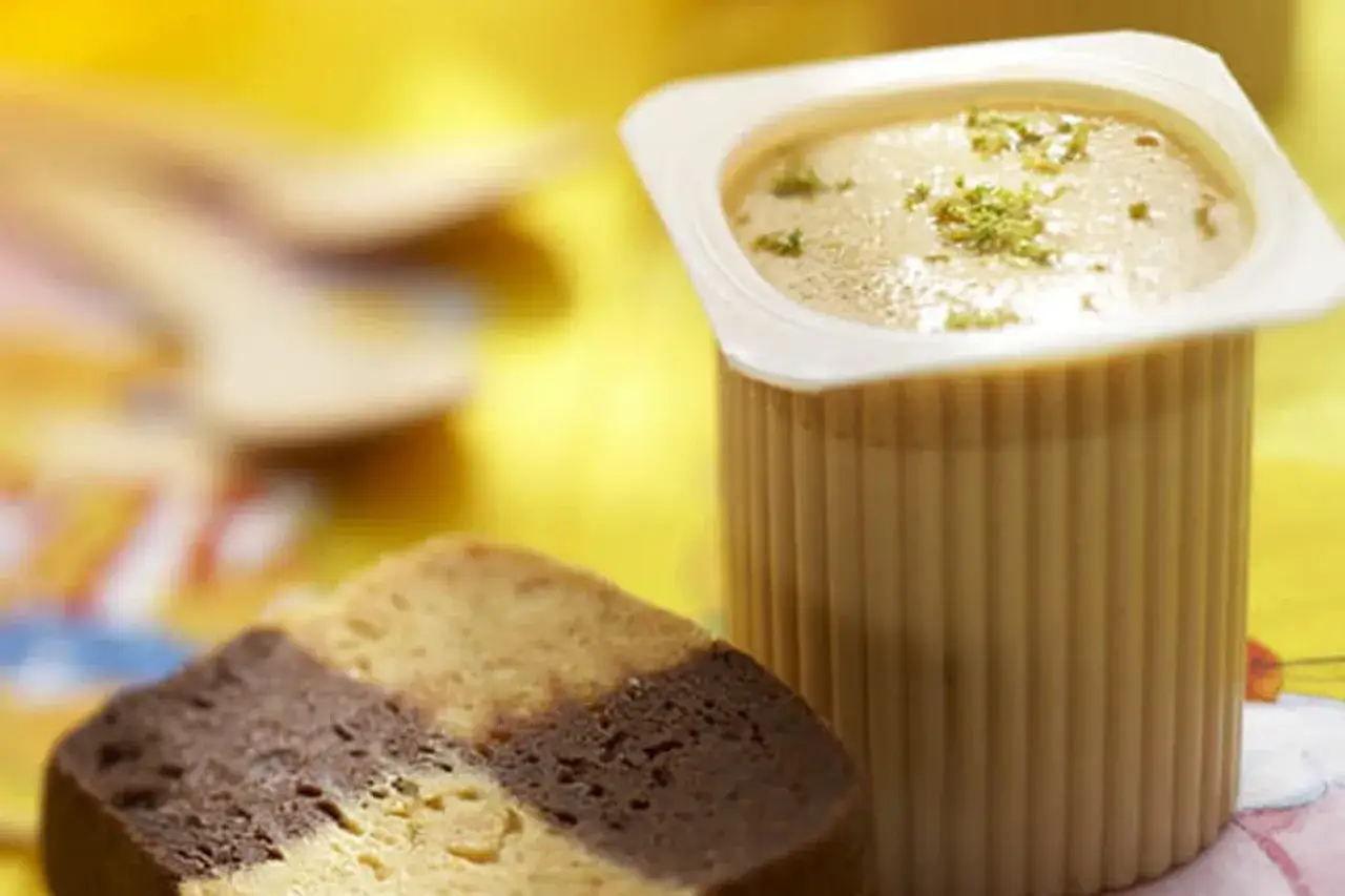 Un dessert cr&eacute;meux dans un pot, garni d'herbes, &agrave; c&ocirc;t&eacute; d'une tranche de g&acirc;teau marbr&eacute;. Une id&eacute;e de recette avec petit suisse nature.