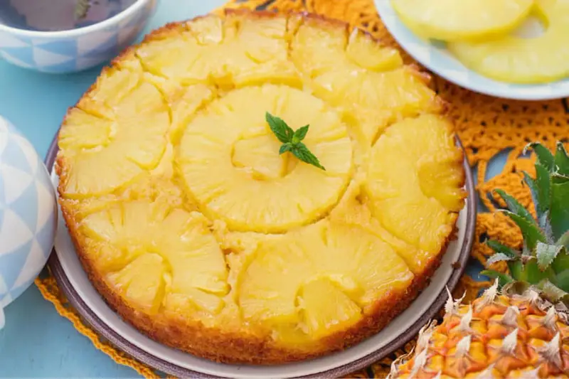 Gâteau renversé aux ananas, garni de menthe fraîche. Une délicieuse recette de gâteau ananas, parfaite pour le dessert.